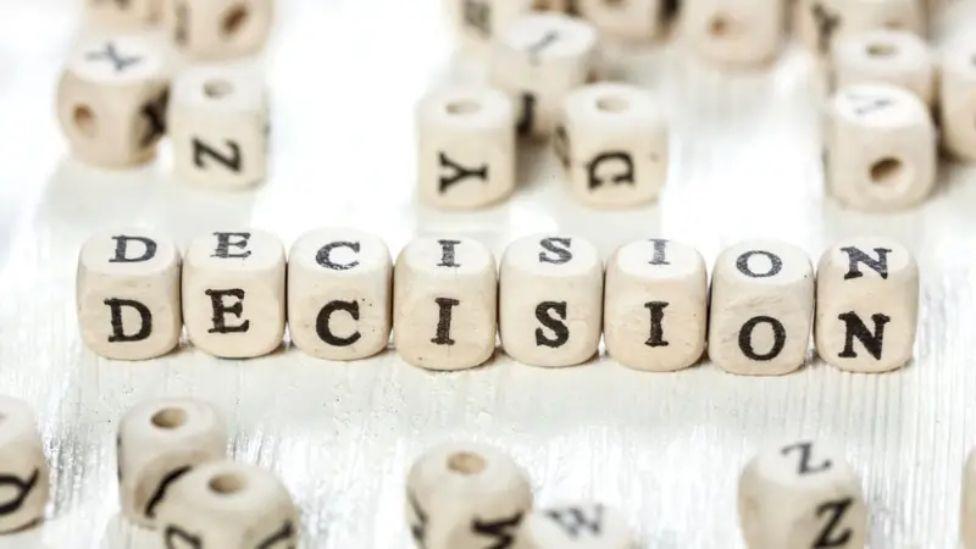 Ocho dados con letras colocados sucesivamente para formar la palabra "decisión".