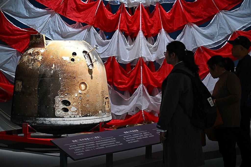 Unas personas ven la cápsula Chang'e 6 en una exposición